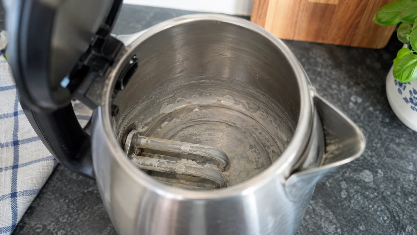Vodní kámen usazený na topné spirále rychlovarné konvice